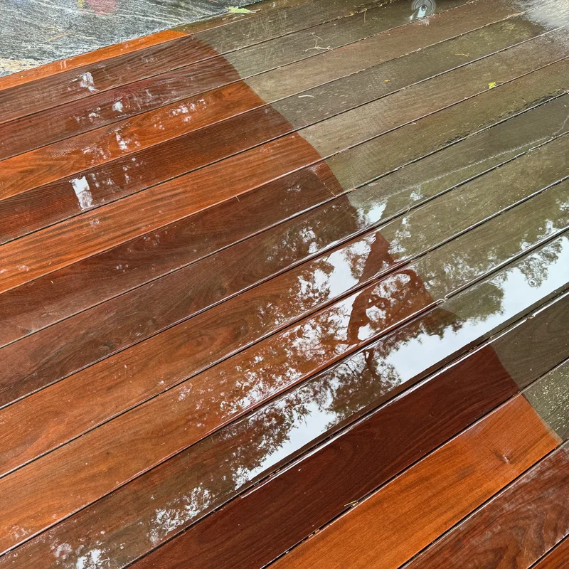 Deck cleaning in Hamilton in progress showing dramatic before and after comparison with grey weathered wood transformed to vibrant reddish-brown